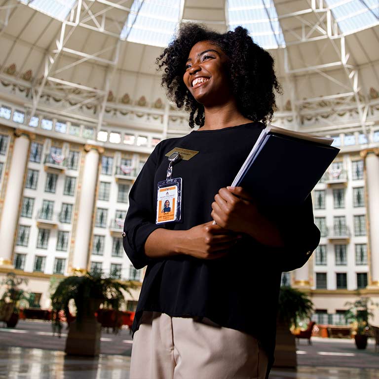 A student carrying a folder walks through the West Baden Springs Hotel.
