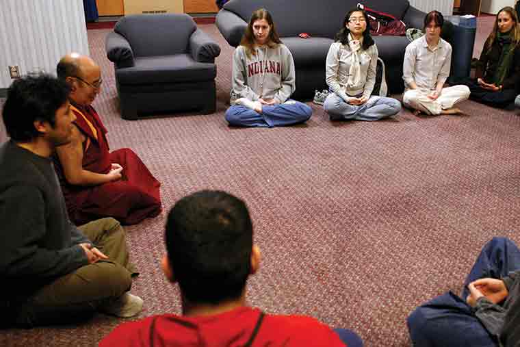 Students meditate with Buddhist monk