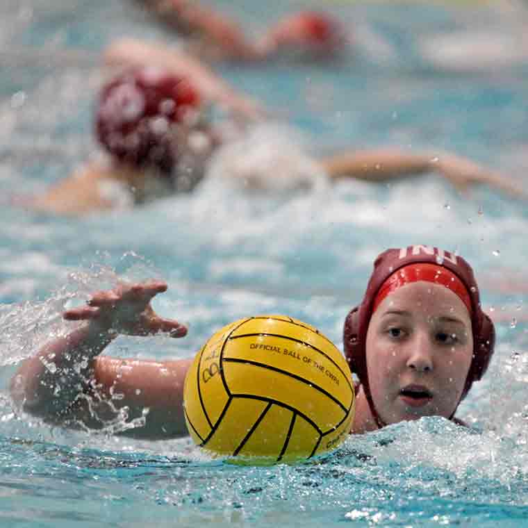 IU's women's water polo team player in the water with the ball 