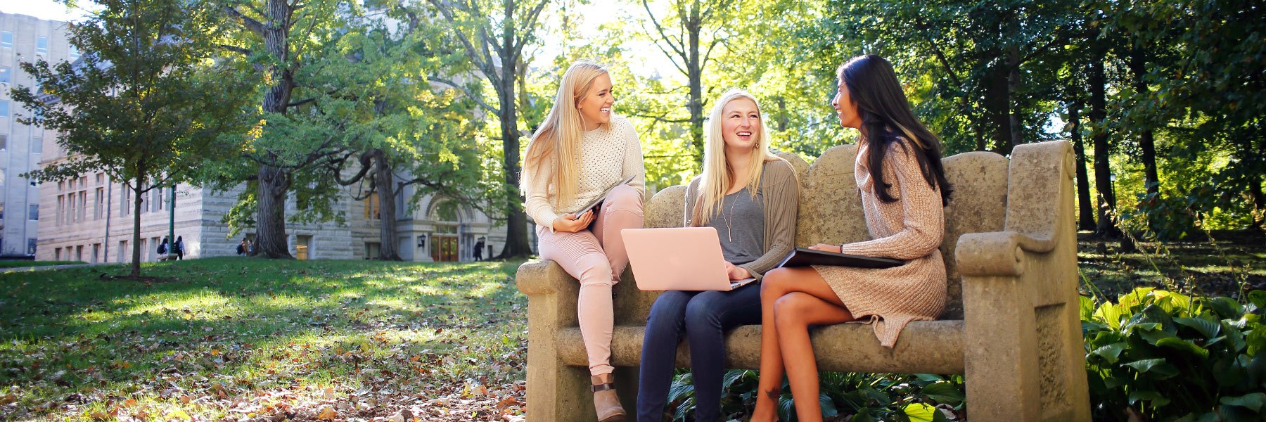 three students visit outdoors on campus