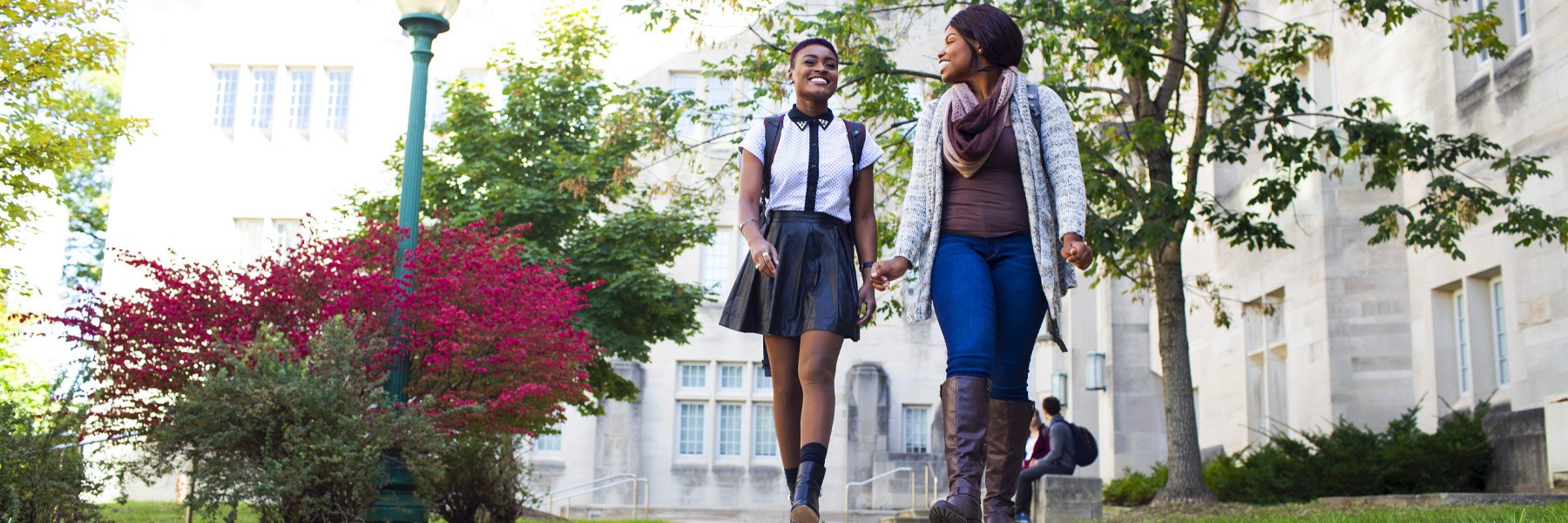 Two students walk across campus