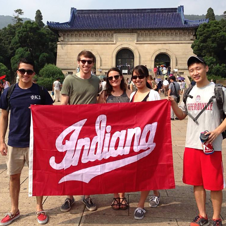 Students hold up a an Indiana flag in China. 