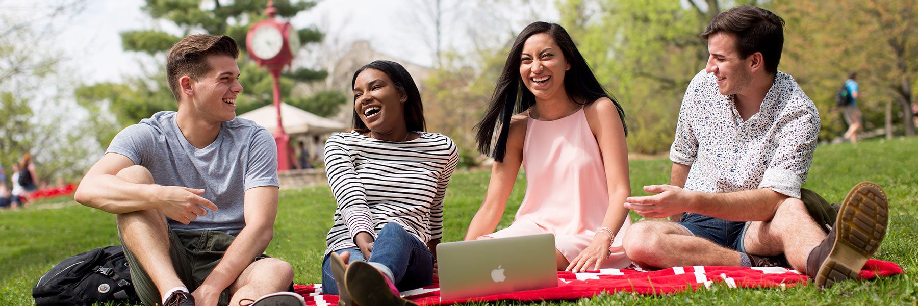Students sit outdoors on campus.