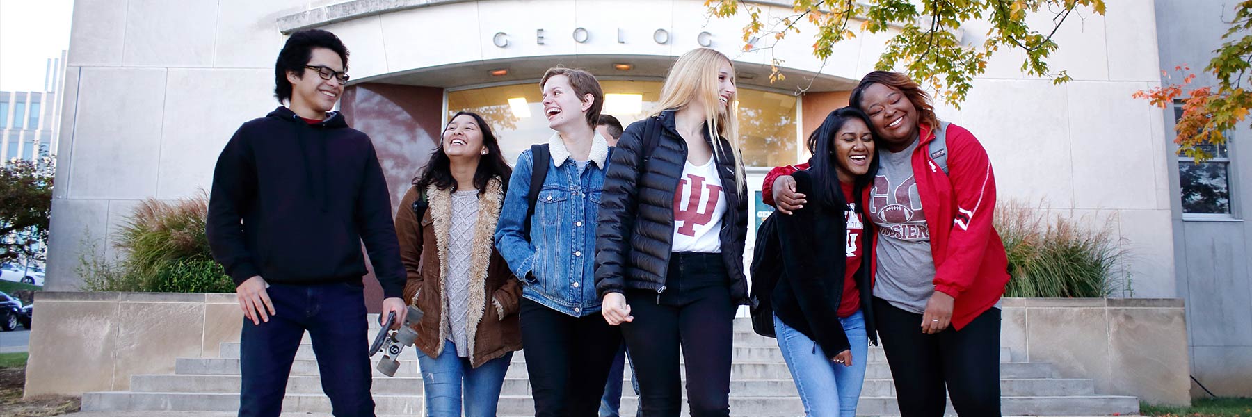 A group of students walks in front of the Geology building.