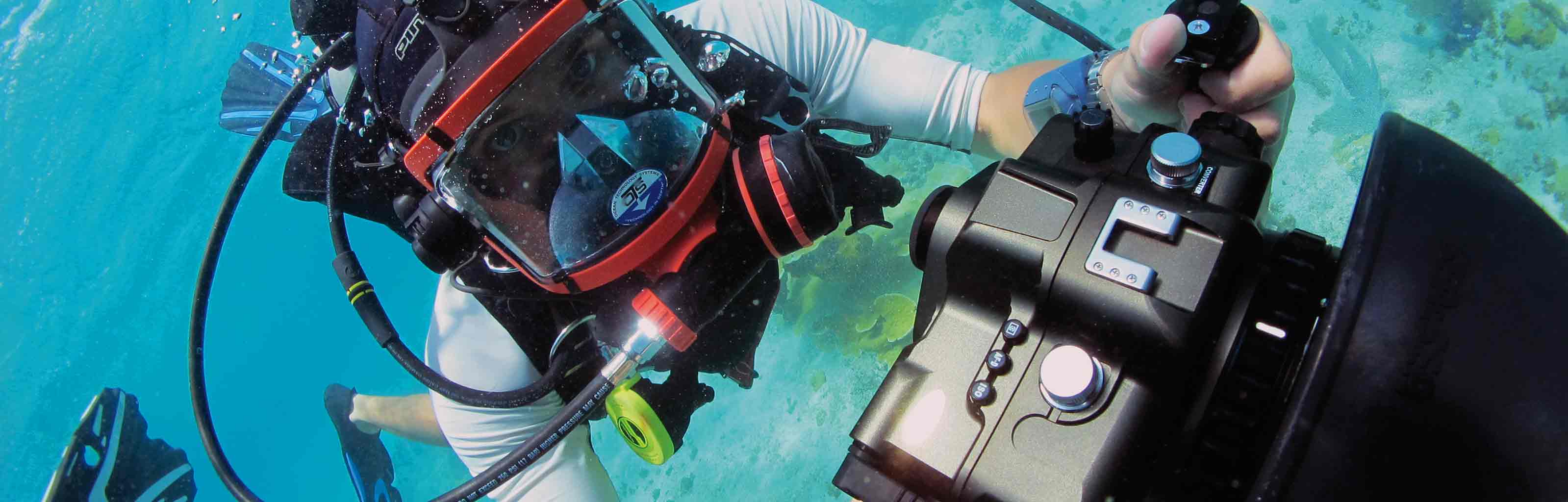 A student diving underwater with a camera