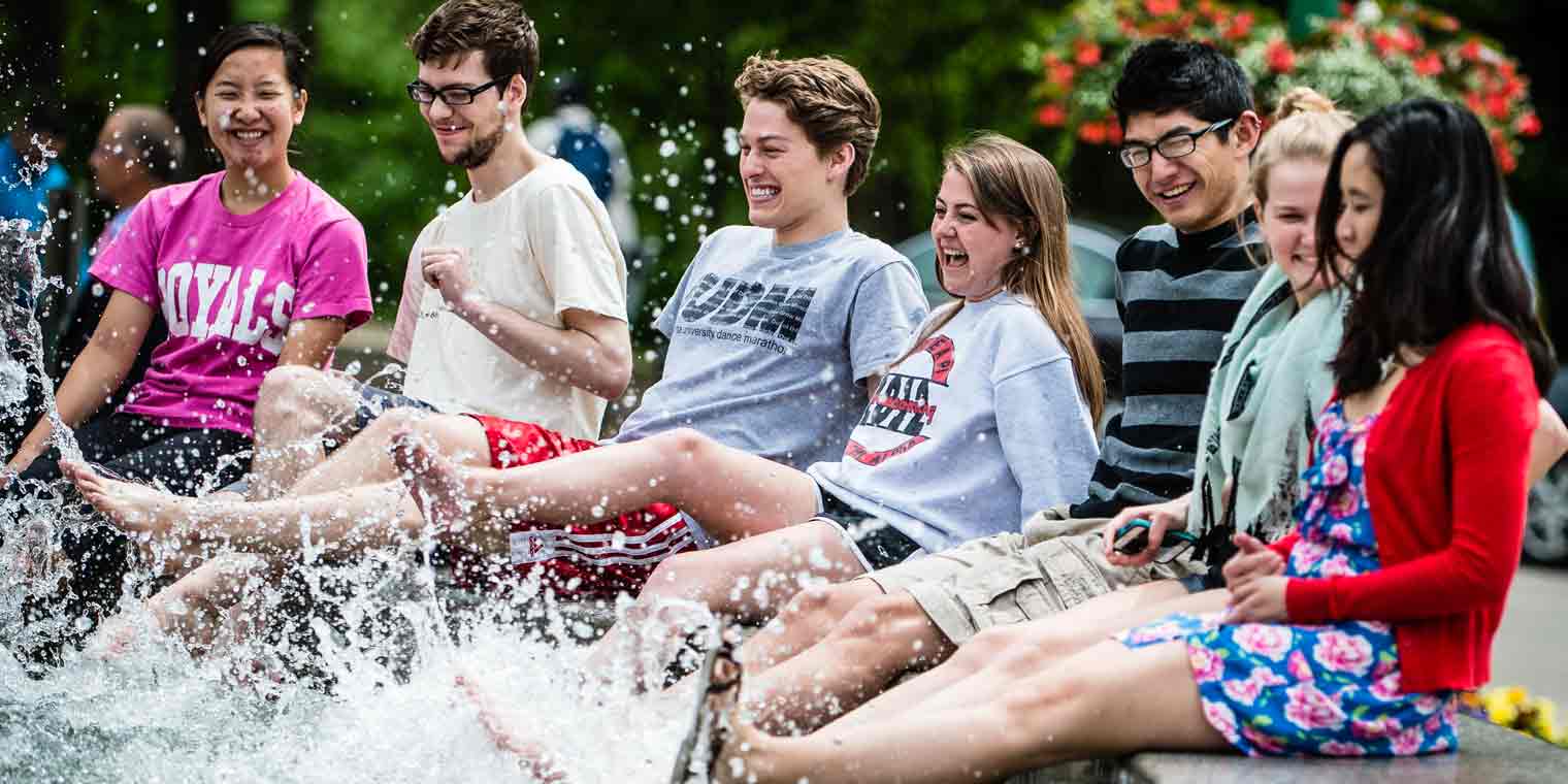 Students dipping their feet in Showalter fountain